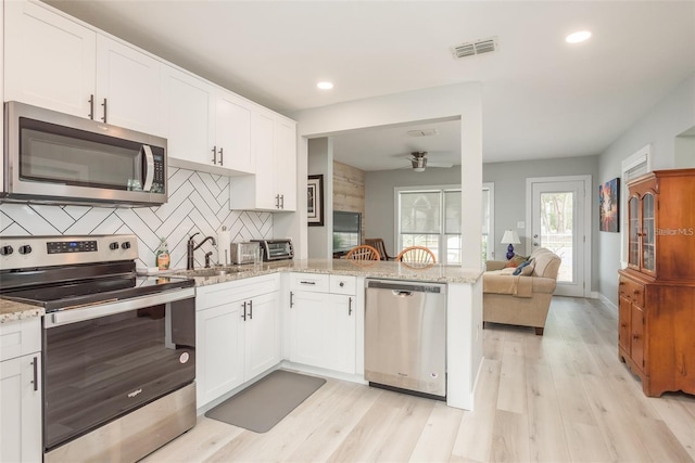 kitchen featuring white cabinetry, kitchen peninsula, sink, and appliances with stainless steel finishes