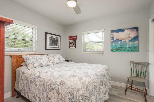 bedroom featuring multiple windows, ceiling fan, and light wood-type flooring