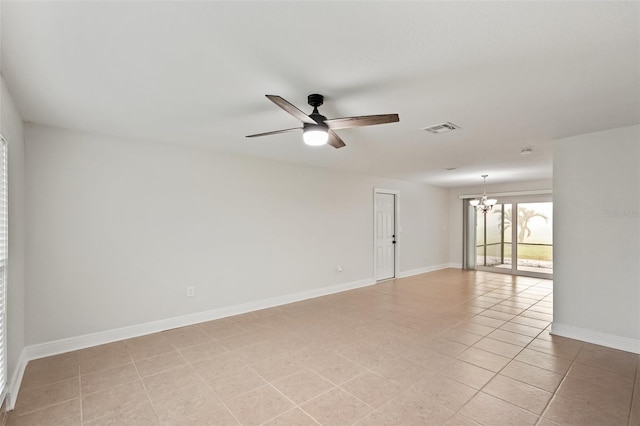 tiled spare room with ceiling fan with notable chandelier