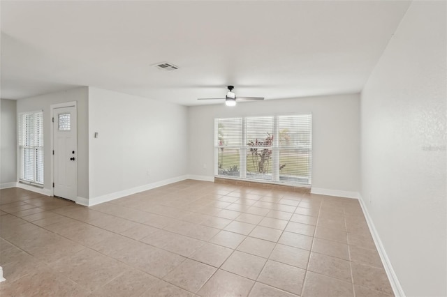 spare room with ceiling fan and light tile patterned floors