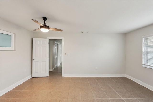 tiled spare room with ceiling fan