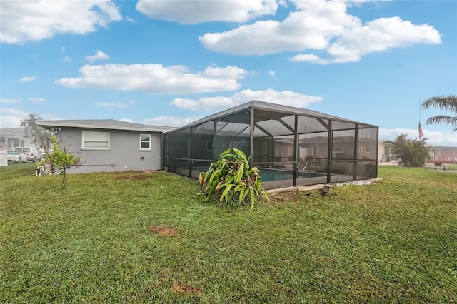 rear view of property featuring a lawn and glass enclosure