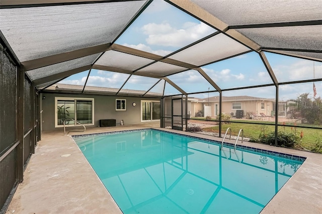 view of swimming pool featuring glass enclosure and a patio