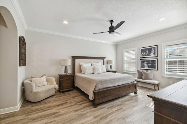 bedroom with ceiling fan, light hardwood / wood-style floors, a textured ceiling, and ornamental molding