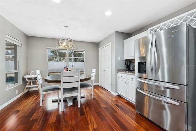 dining space featuring dark hardwood / wood-style floors and an inviting chandelier