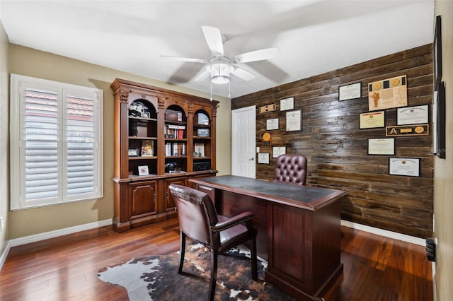 office with wood walls, ceiling fan, and dark hardwood / wood-style floors