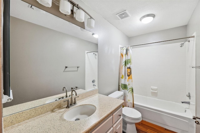 full bathroom with shower / bath combination with curtain, a textured ceiling, toilet, vanity, and hardwood / wood-style flooring