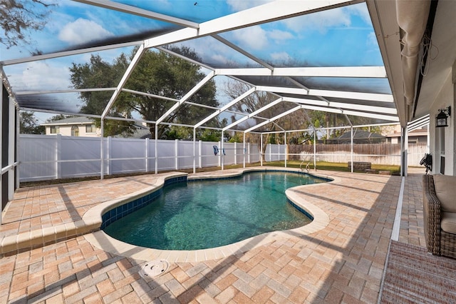 view of swimming pool featuring glass enclosure and a patio area