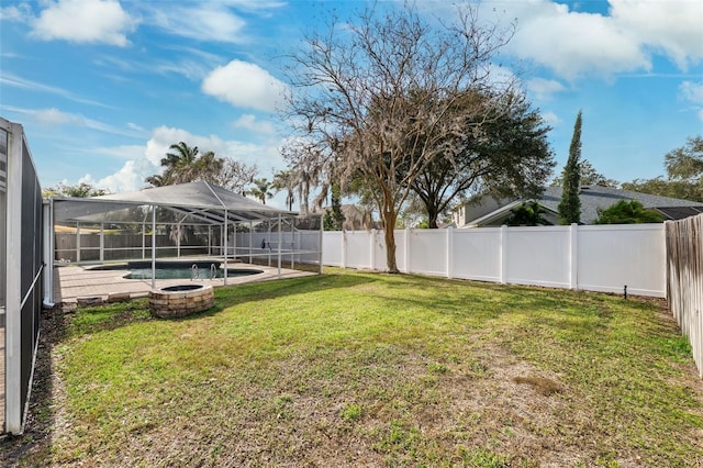 view of yard with glass enclosure and a fenced in pool