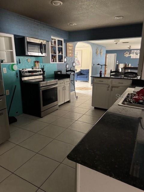 kitchen featuring white cabinets, light tile patterned floors, and appliances with stainless steel finishes