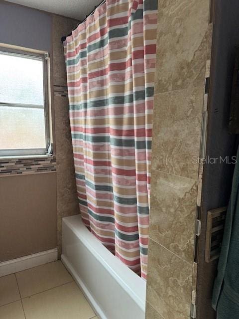 bathroom with tile patterned flooring and shower / bath combo with shower curtain