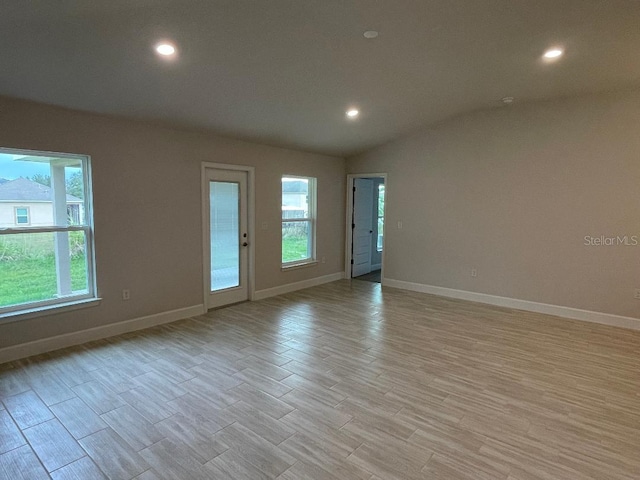 spare room with plenty of natural light and vaulted ceiling