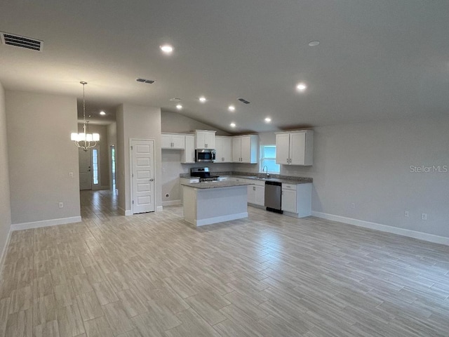 kitchen with white cabinetry, a center island, stainless steel appliances, and light wood-type flooring