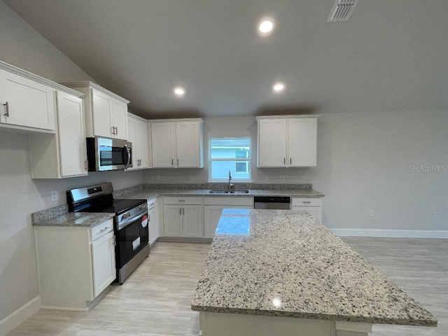 kitchen featuring white cabinets, a kitchen island, sink, and appliances with stainless steel finishes