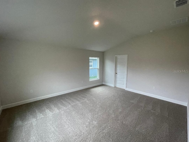 empty room with carpet floors and vaulted ceiling