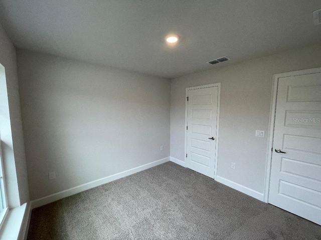 unfurnished bedroom featuring dark colored carpet