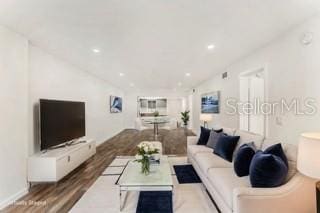 living room with vaulted ceiling and light wood-type flooring