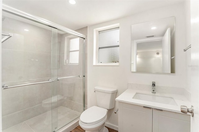 bathroom with vanity, toilet, and a shower with shower door