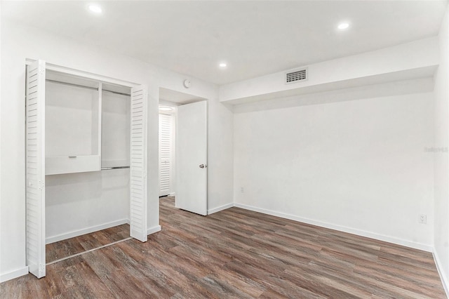 unfurnished bedroom with dark hardwood / wood-style floors and a closet