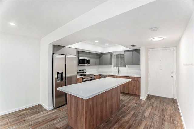 kitchen featuring sink, a kitchen island, hardwood / wood-style floors, and appliances with stainless steel finishes