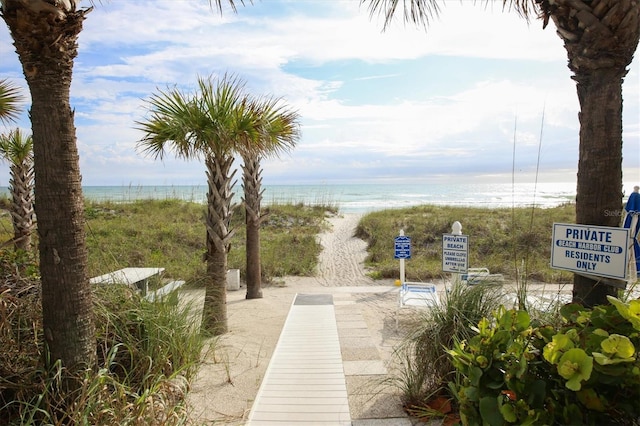 surrounding community with a water view and a view of the beach