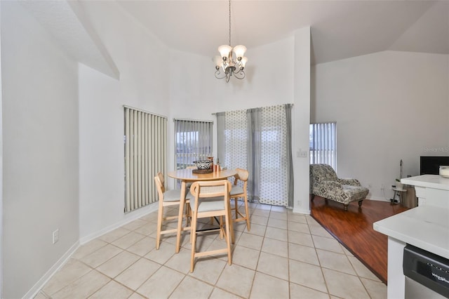 dining space with light tile patterned floors, lofted ceiling, and a notable chandelier