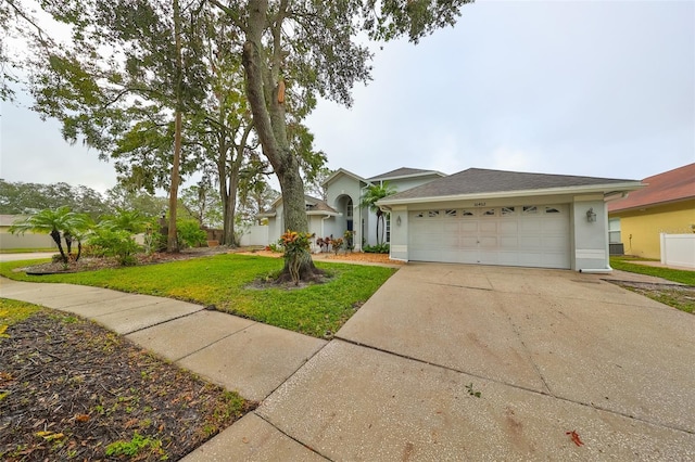 single story home with a garage and a front lawn