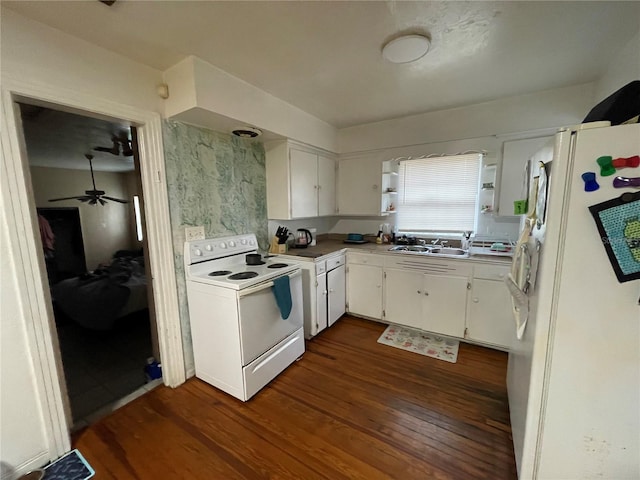 kitchen with white cabinets, dark hardwood / wood-style flooring, white appliances, and sink