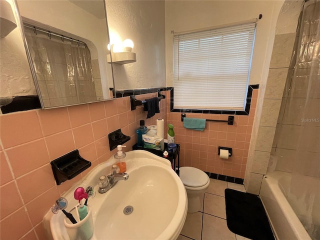 full bathroom featuring shower / bath combo, tile patterned floors, sink, tile walls, and toilet