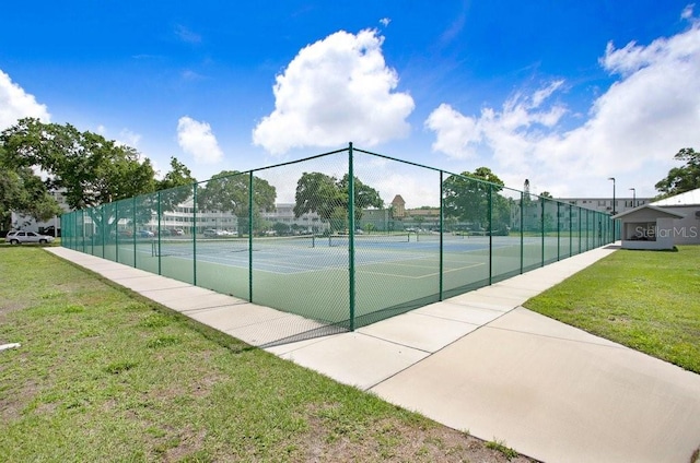 view of sport court with a lawn