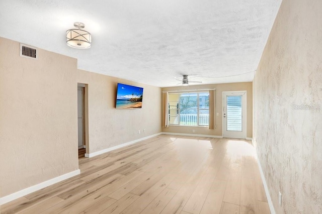 empty room with ceiling fan and light hardwood / wood-style flooring