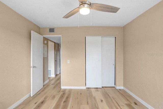 unfurnished bedroom featuring ceiling fan, light wood-type flooring, and a closet