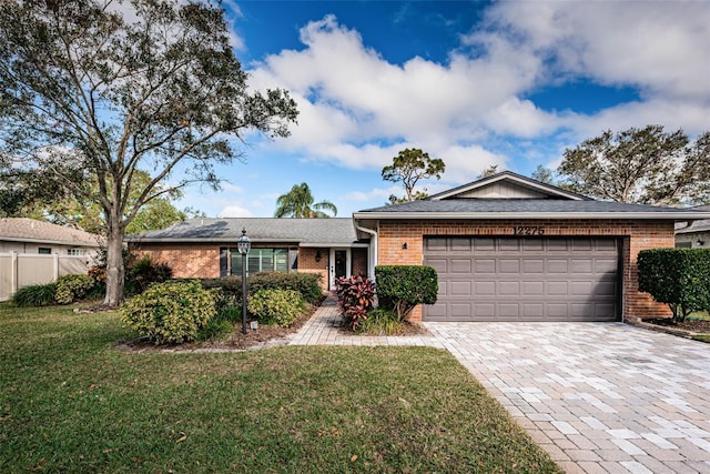 ranch-style house with a garage and a front lawn