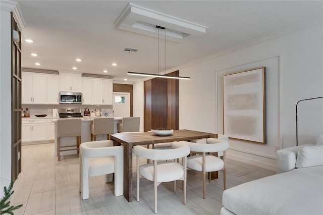 dining space featuring ornamental molding and sink