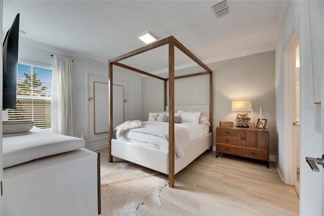 bedroom with light hardwood / wood-style flooring and crown molding