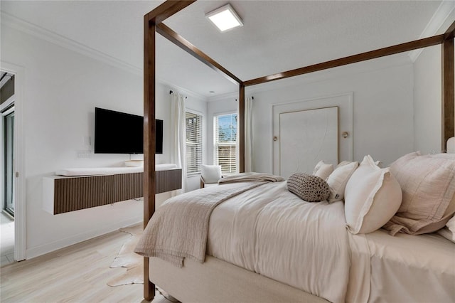 bedroom featuring a textured ceiling, light hardwood / wood-style floors, and crown molding