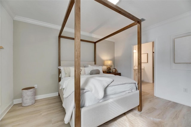 bedroom featuring light wood-type flooring, connected bathroom, and crown molding