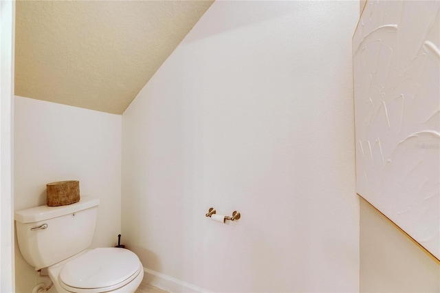 bathroom featuring toilet and lofted ceiling