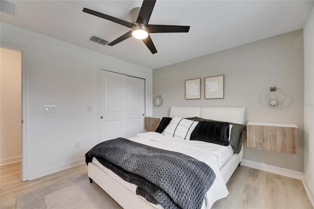 bedroom with ceiling fan, light hardwood / wood-style floors, and a closet