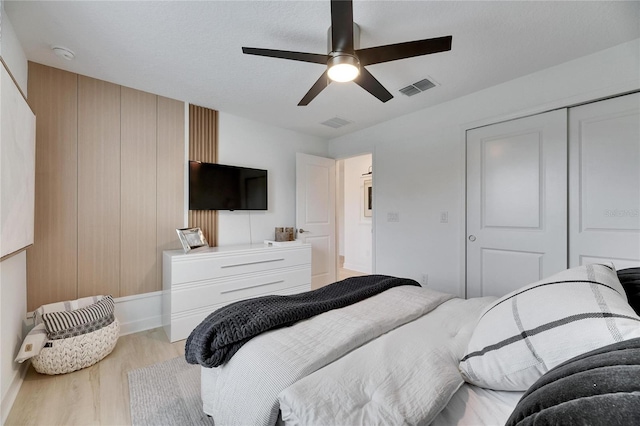 bedroom featuring a closet, light hardwood / wood-style flooring, and ceiling fan