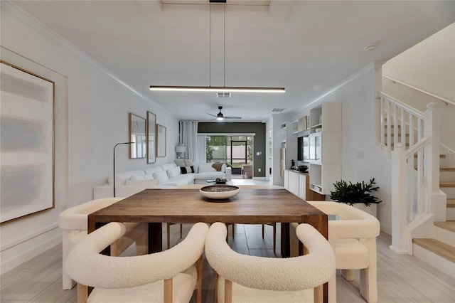 dining area featuring light hardwood / wood-style flooring, ceiling fan, and crown molding