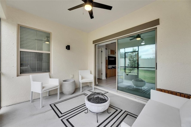 view of patio with ceiling fan and an outdoor fire pit