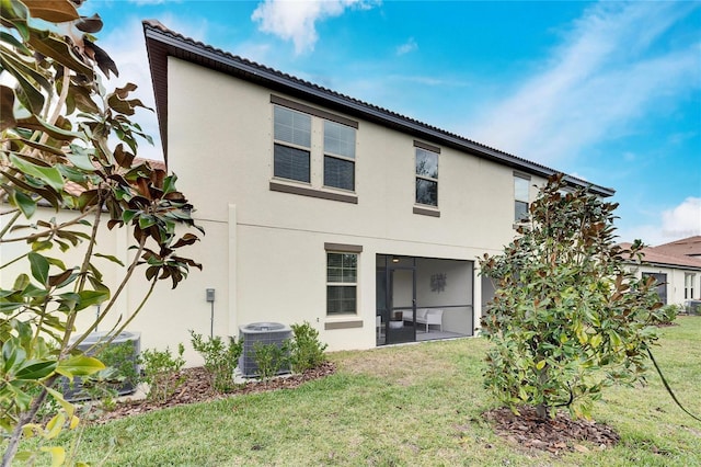 back of property featuring a yard, central AC, and a sunroom