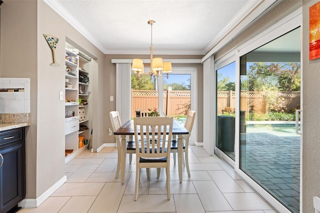 tiled dining area with ornamental molding, a textured ceiling, and a notable chandelier