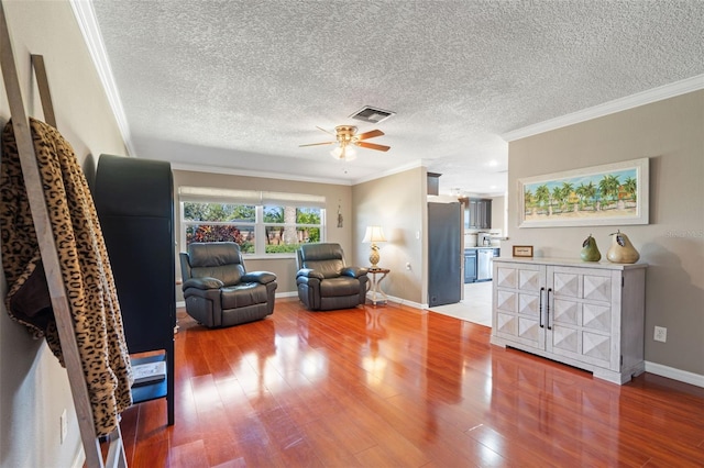 living room featuring hardwood / wood-style flooring, ceiling fan, ornamental molding, and a textured ceiling