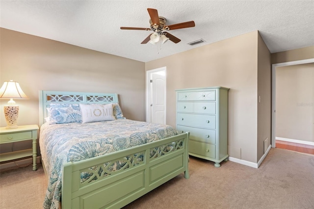 carpeted bedroom with ceiling fan and a textured ceiling