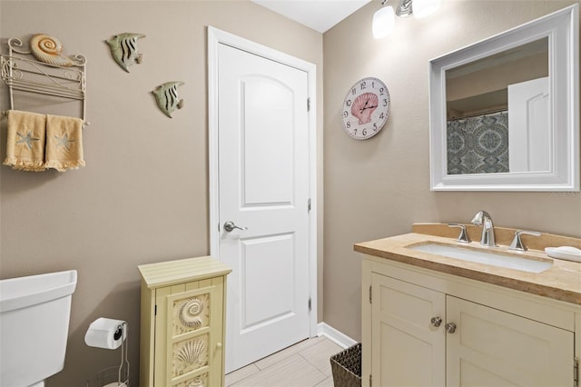 bathroom with tile patterned flooring, vanity, and toilet