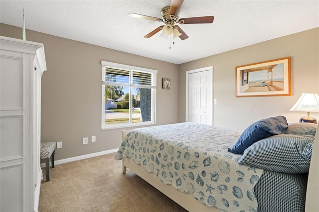 carpeted bedroom featuring a textured ceiling, a closet, and ceiling fan