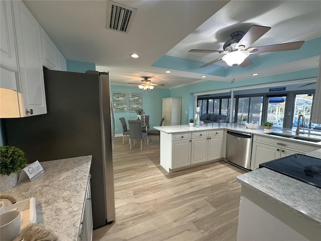 kitchen with white cabinets, sink, ornamental molding, appliances with stainless steel finishes, and kitchen peninsula