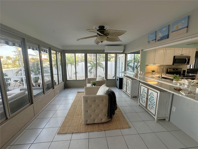 sunroom / solarium featuring an AC wall unit, ceiling fan, and sink